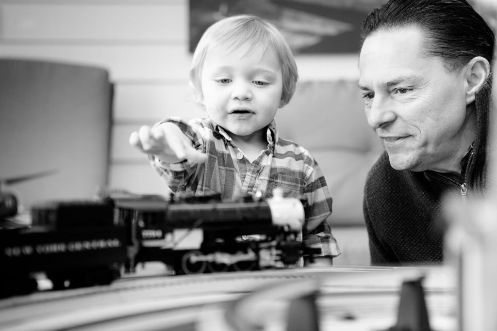 a father plays with the model train set with his son