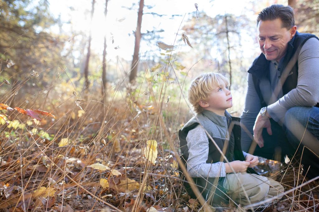 a boy and his father sit in the woods thinking