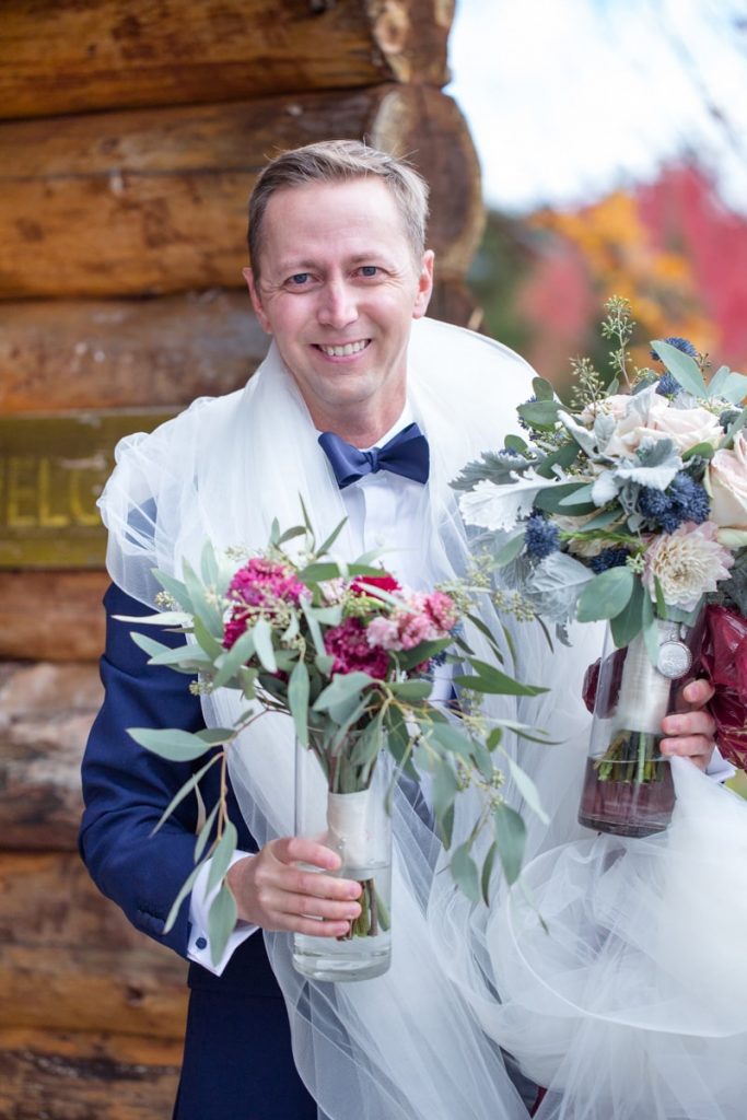 groom carries bouquets