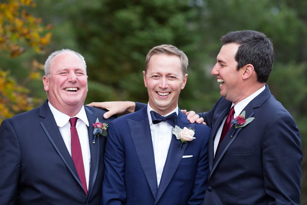 groomsman and best man laugh with their friend