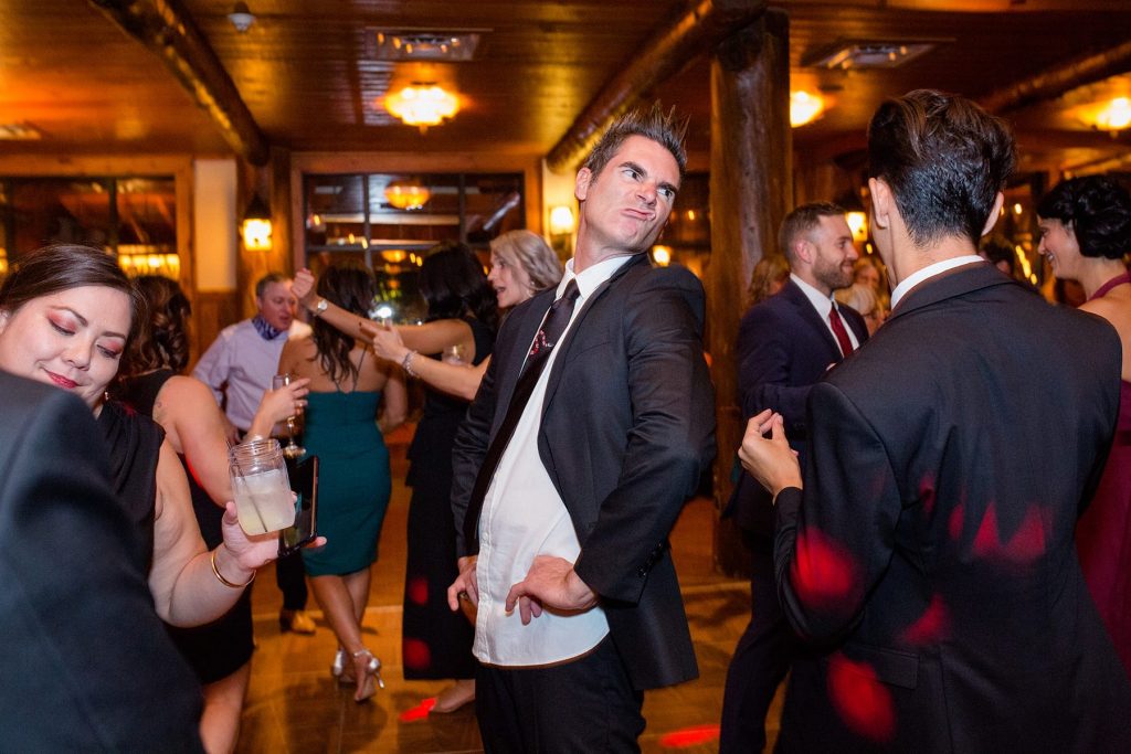 man makes a funny face while dancing at a destination wedding