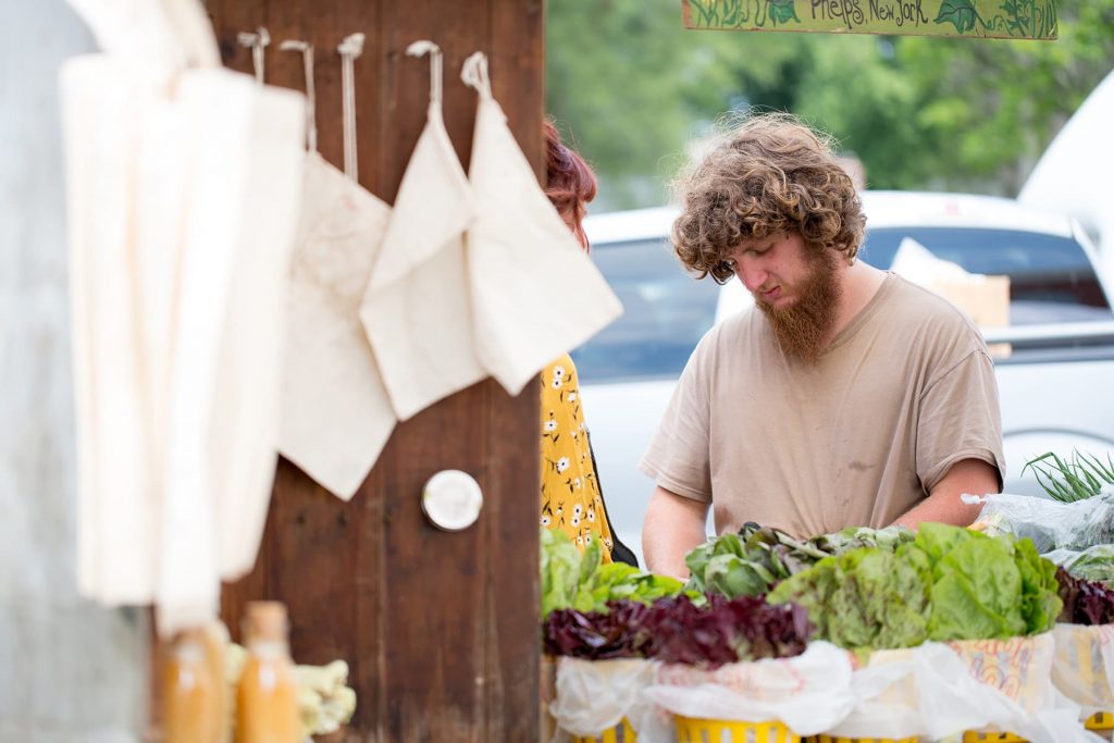 A man from Fellenz Family Farm in Phelps, NY prepares his stand for the market