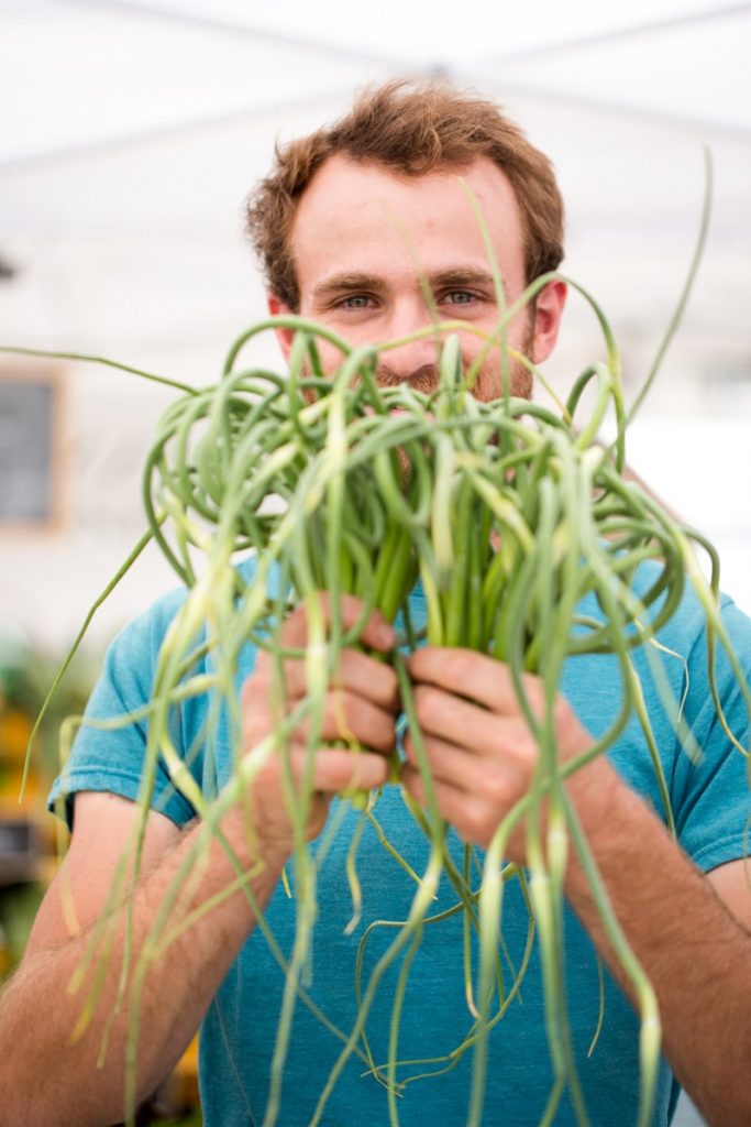 James from Buzz Garden holds up some curly garlic