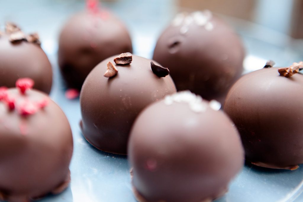 chocolate truffles covered with raspberries, salt, chocolate and nuts