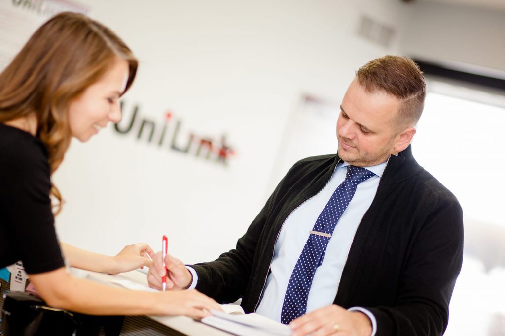 receptionist at UniLink in Rochester greets customer