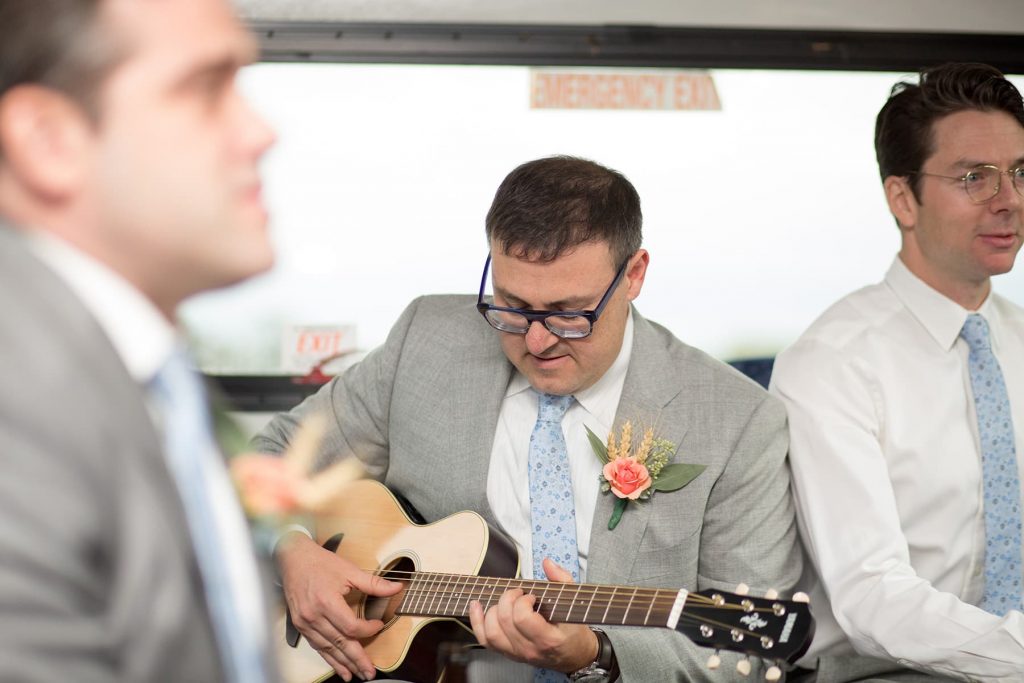 the groomsmen are singing in the bus