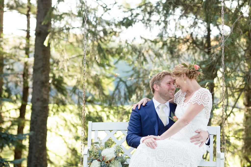 bride and groom have a portrait on the swing