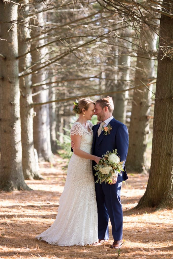 husband and wife at their wedding have a portrait in the woods