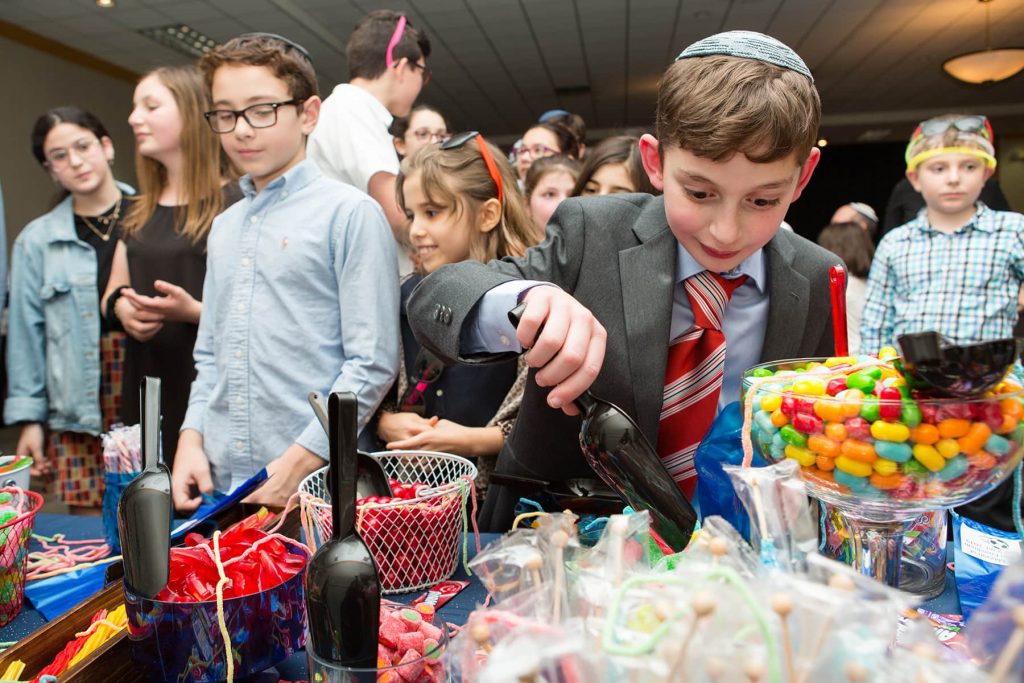 boy loads up his bag full of candy at his party