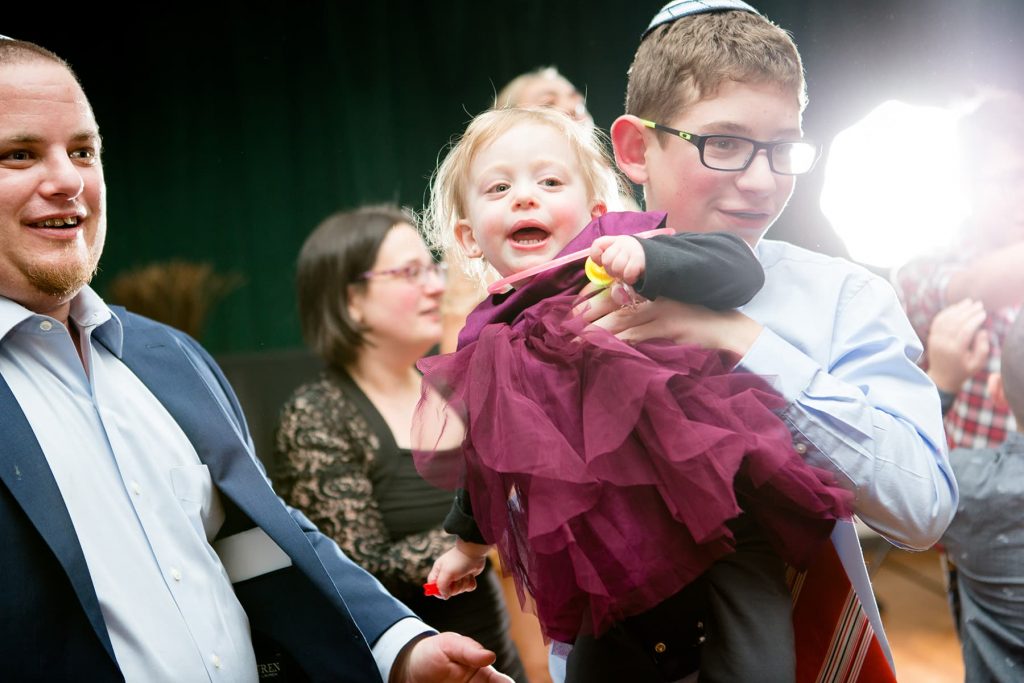 mitzvah photographer in Rochester captures a baby in her brother's arms dancing