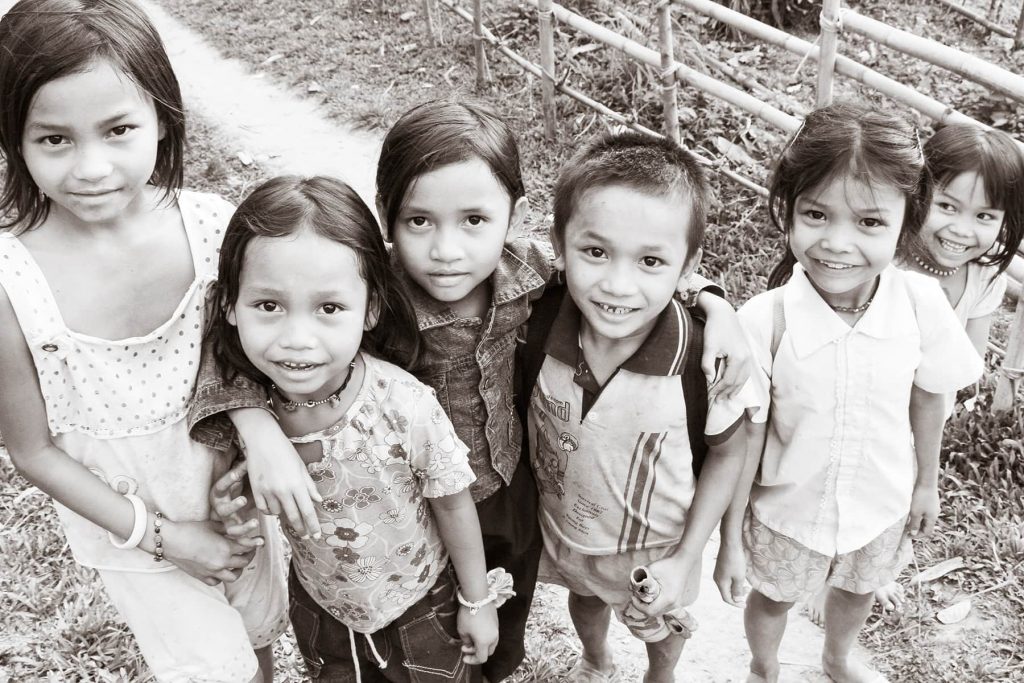 young children in a village crowd around the photographer