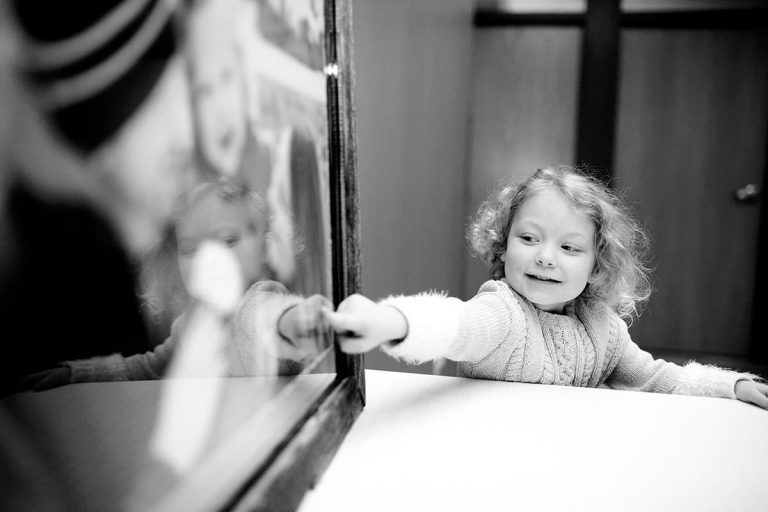 a little girl pointing to her family portrait