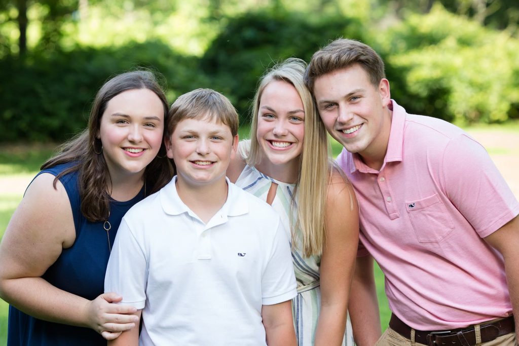 4 siblings smile together during their family session