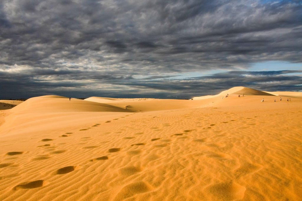 white sand dunes with a dark sky