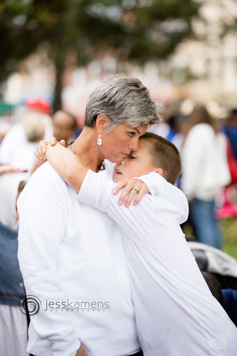 a mother hugs and comforts her son who is not allowed in school due to the religious exemption repeal