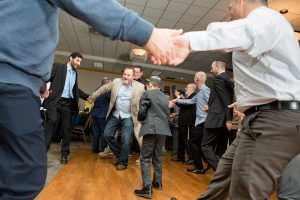 men dance the hora together during a bar mitzvah in rochester ny